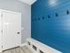 A welcoming entryway featuring a blue accent wall, bench with storage, and hooks for coats at 1723 Fletcher Ave, Indianapolis, IN 46203