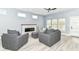Bright living room with a modern fireplace, ceiling fan, and stylish gray armchairs at 1723 Fletcher Ave, Indianapolis, IN 46203