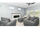 Cozy living room features a modern fireplace, gray sofas, and bright natural light at 1723 Fletcher Ave, Indianapolis, IN 46203