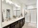 Modern bathroom featuring a double vanity, quartz counters, and glass-enclosed shower with white subway tile surround at 17319 Henslow Dr, Westfield, IN 46074
