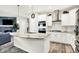 Open kitchen with a curved island, stainless steel appliances, and a seamless flow to the living area and fireplace at 17319 Henslow Dr, Westfield, IN 46074
