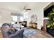 Cozy living room boasts a stone fireplace, ceiling fan, and large window that provides ample natural light at 17319 Henslow Dr, Westfield, IN 46074