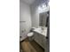 This well lit bathroom features wood floors, a vanity sink, a toilet, and a shower at 1836 Queensbridge Cir, Indianapolis, IN 46219