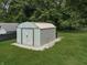 Exterior view of a metal storage shed, situated on a gravel bed, surrounded by green grass and trees at 2015 Deer Lake Dr, Martinsville, IN 46151