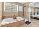 Relaxing soaking tub with glass enclosed shower and a large window at 2115 Napa Cir, Indianapolis, IN 46214