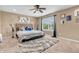 Cozy bedroom with a ceiling fan, large window, decorative pillows and carpeted floor at 2115 Napa Cir, Indianapolis, IN 46214