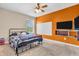 Bedroom with a bed and a tv mounted on a bright orange wall at 2115 Napa Cir, Indianapolis, IN 46214