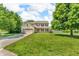 Beautiful two-story home with green lawn and trees in the front yard under a cloudy blue sky at 2115 Napa Cir, Indianapolis, IN 46214