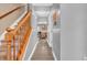 Hallway with wood floors and a wooden staircase with neutral-colored walls, leading to other rooms at 2115 Napa Cir, Indianapolis, IN 46214