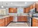 Modern kitchen with stainless steel appliances, granite countertops, and wood cabinetry at 2115 Napa Cir, Indianapolis, IN 46214
