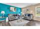 Cozy living room with gray sofas, a glass coffee table, and a bright blue accent wall at 2115 Napa Cir, Indianapolis, IN 46214