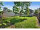 Well-manicured backyard with green lawn, privacy fence, and mature trees at 22 N Bolton Ave, Indianapolis, IN 46219