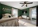 Cozy bedroom with green walls, wood floors, windows, and ample space for personalization at 22 N Bolton Ave, Indianapolis, IN 46219