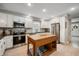 Bright kitchen with white cabinets, stainless steel appliances, marble backsplash, and wood kitchen island at 22 N Bolton Ave, Indianapolis, IN 46219