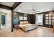 Modern main bedroom with dark walls, wood floors, a ceiling fan, and unique decor at 22 N Bolton Ave, Indianapolis, IN 46219