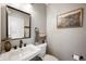 Modern powder room featuring a square mirror, pedestal sink, and gray walls with a framed print at 22 N Bolton Ave, Indianapolis, IN 46219