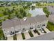 Aerial view of townhomes with driveways in a scenic community featuring ponds and greenery at 258 Coatsville Dr, Westfield, IN 46074