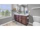 Bathroom featuring double sinks, a decorative mirror, and window allowing for abundant natural light at 258 Coatsville Dr, Westfield, IN 46074