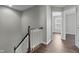 Bright hallway with wooden railing and hardwood flooring, showcasing seamless transition between levels at 258 Coatsville Dr, Westfield, IN 46074
