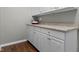 Well-organized laundry area with white cabinets, laminate countertop, and stylish wood-look flooring at 258 Coatsville Dr, Westfield, IN 46074