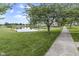 Scenic pond view featuring lush greenery and a sidewalk, perfect for relaxing strolls in the community at 258 Coatsville Dr, Westfield, IN 46074