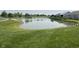 Community pond surrounded by lush green grass and shrubbery at 258 Coatsville Dr, Westfield, IN 46074