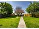 Wide green backyard with concrete path that leads to a home with wood fence at 270 W Broadway St, Greenwood, IN 46142