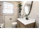 Updated bathroom boasts modern vanity, oval mirror, marble accents and bright light from large window at 270 W Broadway St, Greenwood, IN 46142