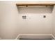Clean laundry room featuring washer/dryer hookups and a rustic wooden shelf for storage at 270 W Broadway St, Greenwood, IN 46142