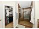Bathroom with glass enclosed shower and open closet. The shower has neutral colored tile and there is a white robe hanging in it at 2805 Rylee Ct, Greenwood, IN 46143