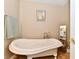 Bright bathroom features a claw foot tub, neutral walls, and vintage-inspired decor with a view of a side sink at 2805 Rylee Ct, Greenwood, IN 46143