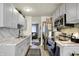 Kitchen showcasing stainless steel appliances, grey cabinets, and marble-style countertops at 2832 Hillside Ave, Indianapolis, IN 46218