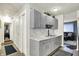 View of kitchen with grey cabinets, marbled counters, leading to living spaces, and storage at 2832 Hillside Ave, Indianapolis, IN 46218