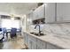 A kitchen featuring marble countertops, a black faucet, grey cabinets, and stainless steel sink at 2832 Hillside Ave, Indianapolis, IN 46218
