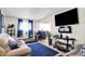 Bright living room with plush seating, a large television, and a view into the dining area at 2832 Hillside Ave, Indianapolis, IN 46218