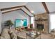 Spacious living room with a stone fireplace and vaulted ceiling with wood beams at 2925 Horse Hill East Dr, Indianapolis, IN 46214