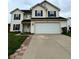 Two-story home featuring a two car garage, black shutters, and a well-manicured lawn at 3065 Hemlock Way, Indianapolis, IN 46203
