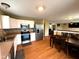 Eat-in kitchen with stainless appliances, white cabinets, and hardwood flooring adjoining the living area at 3065 Hemlock Way, Indianapolis, IN 46203