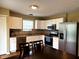 Well-lit kitchen features stainless steel appliances, white cabinets, and hardwood flooring at 3065 Hemlock Way, Indianapolis, IN 46203