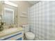 Well-lit bathroom with a single sink vanity and blue and white shower curtain at 311 Thornberry Dr, Carmel, IN 46032
