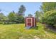 Red backyard storage shed with a ramp on a sunny day at 311 Thornberry Dr, Carmel, IN 46032
