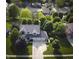 Aerial view of a landscaped home featuring a three-car garage and lush trees at 318 Meadowview Ln, Greenwood, IN 46142