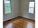 A bright bedroom featuring original hardwood floors and windows at 330 S Butler Ave, Indianapolis, IN 46219