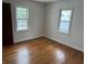 A bright bedroom featuring original hardwood floors and windows at 330 S Butler Ave, Indianapolis, IN 46219