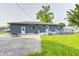 Lawn and back of home with dark siding, bright trim, and a small backyard seating area at 3414 Ferncliff Ave, Indianapolis, IN 46227