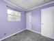 This bedroom features purple walls, neutral carpet, and a window that lets in natural light at 3414 Ferncliff Ave, Indianapolis, IN 46227