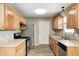 Well-lit kitchen featuring stainless steel appliances, wooden cabinets, and laminate flooring at 3414 Ferncliff Ave, Indianapolis, IN 46227