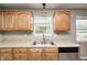 This kitchen features stainless steel appliances, wood cabinets, and a stainless steel sink with a window view at 3414 Ferncliff Ave, Indianapolis, IN 46227