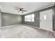 Spacious living room with neutral carpet, ceiling fan, and a large window offering natural light at 3414 Ferncliff Ave, Indianapolis, IN 46227