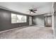 Bright living room featuring neutral carpet, a ceiling fan, and a large window overlooking the front yard at 3414 Ferncliff Ave, Indianapolis, IN 46227